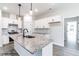 Bright kitchen with white cabinets, granite countertops, a kitchen island with a sink and pendant lights at 123 Pretty Run Branch Ln, Wendell, NC 27591