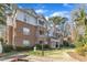 Exterior view of multi-story brick and siding condo complex with manicured lawn at 1700 Tiffany Bay Ct # 303, Raleigh, NC 27609