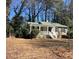 Single story home featuring a cozy front porch and mature trees in the yard at 1704 Delaware Ave, Durham, NC 27705