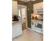 Well-lit kitchen with white appliances, tile flooring, and a glimpse into the adjacent room at 1704 Delaware Ave, Durham, NC 27705