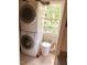 Compact laundry area with stacked washer and dryer and a window for natural light at 1704 Delaware Ave, Durham, NC 27705