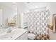 Well-lit bathroom featuring a white vanity with a sink, a toilet, and a floral shower curtain at 174 Arrow Ln, Middlesex, NC 27557