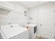 Functional laundry room with modern white appliances and convenient overhead storage shelving at 174 Arrow Ln, Middlesex, NC 27557