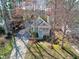 An aerial view of a light blue house surrounded by trees with vibrant pink blossoms at 1821 Kelly Glen Dr, Apex, NC 27502