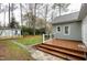 Backyard view featuring a small shed, wooden deck, and well-manicured grass at 1821 Kelly Glen Dr, Apex, NC 27502