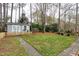 Backyard view with a small shed and a grass area with well-maintained landscaping at 1821 Kelly Glen Dr, Apex, NC 27502