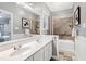 Bathroom featuring double sink vanity, large mirror, and shower-tub combination with tiled surround at 1821 Kelly Glen Dr, Apex, NC 27502