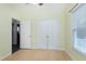Bedroom featuring hardwood floors, natural light, and a double door closet, offering ample storage at 1821 Kelly Glen Dr, Apex, NC 27502