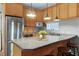Well-equipped kitchen with wood cabinets, stainless steel appliances, and a spacious island at 1821 Kelly Glen Dr, Apex, NC 27502