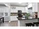 Modern kitchen featuring white cabinets, granite countertops, and a stylish backsplash for a contemporary appeal at 1821 Kelly Glen Dr, Apex, NC 27502