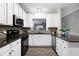 Updated kitchen boasts black appliances, white cabinets, granite countertops, and mosaic backsplash at 1821 Kelly Glen Dr, Apex, NC 27502