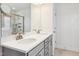 Bright bathroom with a double sink vanity featuring modern faucets, and cabinetry with marble tiling on the walls at 1913 Brodgen Ln, Durham, NC 27703