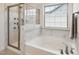 Well-appointed bathroom featuring a separate glass shower and soaking tub, with white marble tiling and modern fixtures at 1913 Brodgen Ln, Durham, NC 27703