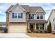 Charming two-story home featuring a stone and gray siding facade, with an attached two-car garage at 1913 Brodgen Ln, Durham, NC 27703
