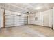 Unfinished garage interior featuring concrete floor, door to backyard, and an automatic garage door opener at 1913 Brodgen Ln, Durham, NC 27703