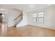 Open-concept living room with light hardwood floors, staircase, and ample natural light at 1913 Brodgen Ln, Durham, NC 27703