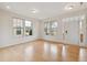 Sunlit living room featuring a large window, light hardwood floors, and a white front door at 1913 Brodgen Ln, Durham, NC 27703