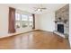 This living room features a stone fireplace, large windows, and gleaming hardwood floors at 1913 Brodgen Ln, Durham, NC 27703