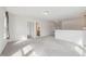Spacious loft area with plush carpeting, neutral walls, and natural light pouring in through the multiple doorways and windows at 1913 Brodgen Ln, Durham, NC 27703