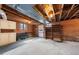 Unfinished basement featuring exposed brick, wood beams, storage and a door to the backyard at 1917 Bivins St, Durham, NC 27707
