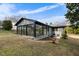 Exterior rear view of the home featuring sunroom, with a brick patio and a well-maintained lawn at 1917 Bivins St, Durham, NC 27707