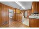 Spacious kitchen boasts wood paneling, hardwood floors and an open floorplan at 1917 Bivins St, Durham, NC 27707