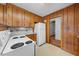Cozy kitchen features wood paneling, white appliances and neutral countertops at 1917 Bivins St, Durham, NC 27707