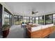 Bright sunroom featuring large windows with backyard views, a ceiling fan, and ample seating at 1917 Bivins St, Durham, NC 27707