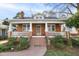 Charming brick home featuring a welcoming front porch, landscaped yard, and classic architectural details at 2005 Glenwood Ave, Raleigh, NC 27608