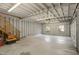 Spacious two-car garage, painted white, features a concrete floor, wooden staircase, and natural light at 2005 Glenwood Ave, Raleigh, NC 27608