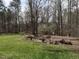 Exterior shot of backyard featuring green lawn, a fire pit, and trees at 206 May Farm Rd, Pittsboro, NC 27312