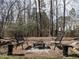 Fire pit area with chairs and stone accents in a wooded backyard setting at 206 May Farm Rd, Pittsboro, NC 27312