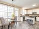Eat-in kitchen features a glass table, white cabinets, and stainless steel appliances at 206 May Farm Rd, Pittsboro, NC 27312