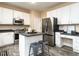 Well-lit kitchen with stainless steel appliances, island with seating, and ample white cabinetry at 206 May Farm Rd, Pittsboro, NC 27312