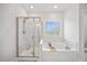 Bright bathroom features a tub and shower combination with white tile and a large window at 213 Chateau Way, Angier, NC 27501