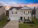 Charming two-story home featuring a welcoming front porch and attached garage with a beautiful sunset backdrop at 213 Chateau Way, Angier, NC 27501