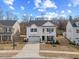A bright, two-story white home boasts a welcoming porch, well-manicured lawn and paved driveway, perfect for Gathering living at 213 Chateau Way, Angier, NC 27501