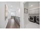 Second floor hallway leading to the laundry room with modern appliances and cabinetry at 213 Chateau Way, Angier, NC 27501