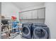 Well-organized laundry room with washer, dryer, utility sink, storage, and shelving at 213 Chateau Way, Angier, NC 27501