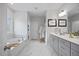 Well-lit bathroom boasting marble tile floors, double vanity, soaking tub, and elegant fixtures at 213 Chateau Way, Angier, NC 27501