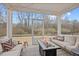 Inviting screened-in porch features comfortable seating, stylish rug, and a cozy fire table for outdoor relaxation at 213 Chateau Way, Angier, NC 27501