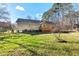 Back exterior view of home with deck, shed and mature tree in a partially wooded lot at 2204 Gentry Dr, Durham, NC 27705