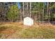 Large backyard featuring a shed with chain link fence and a line of mature trees, providing a private outdoor space at 2204 Gentry Dr, Durham, NC 27705
