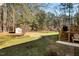 Large backyard featuring a shed, trees, a patio, and an outdoor chair for relaxing or entertaining at 2204 Gentry Dr, Durham, NC 27705