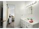 Bathroom with white vanity and mirror is adjacent to a carpeted bedroom at 2204 Gentry Dr, Durham, NC 27705