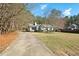 A home with a driveway and shutters surrounded by trees in a partly wooded lot at 2204 Gentry Dr, Durham, NC 27705