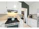Modern kitchen features stainless steel appliances, bright white cabinets, and convenient access to laundry area at 2204 Gentry Dr, Durham, NC 27705
