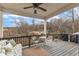 A cozy covered porch with a ceiling fan, outdoor seating, and a view of the backyard trees at 274 Roaring Creek Dr, Garner, NC 27529