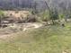 A view of the backyard, including a small ravine and bordering treeline under an overcast sky at 274 Roaring Creek Dr, Garner, NC 27529