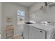Bright laundry room with window, neutral walls, modern washer and dryer, and ample shelving at 274 Roaring Creek Dr, Garner, NC 27529